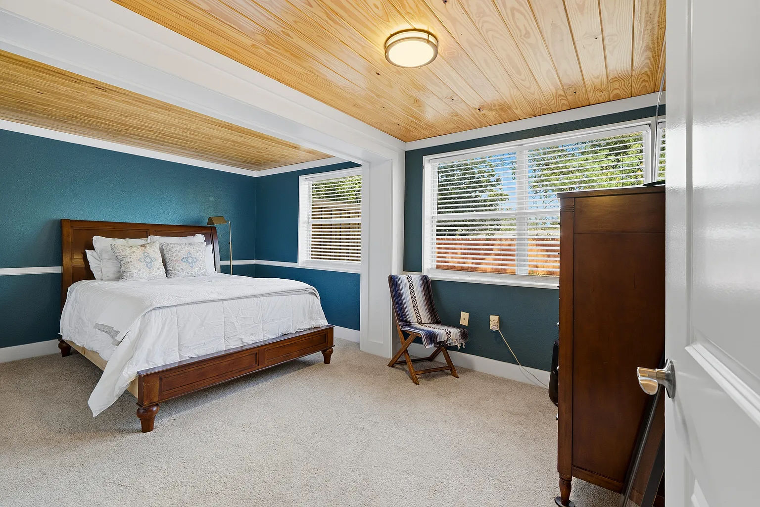 Bedroom with blue walls and wood ceiling